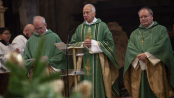 Zu sehen sind drei Priester in grünen Roben während einer Messe
